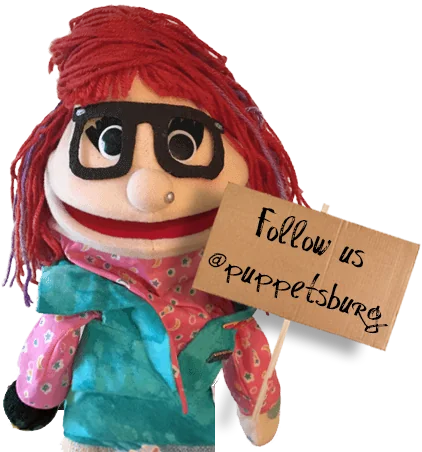 Clementine puppet holding a Puppetsburg sign